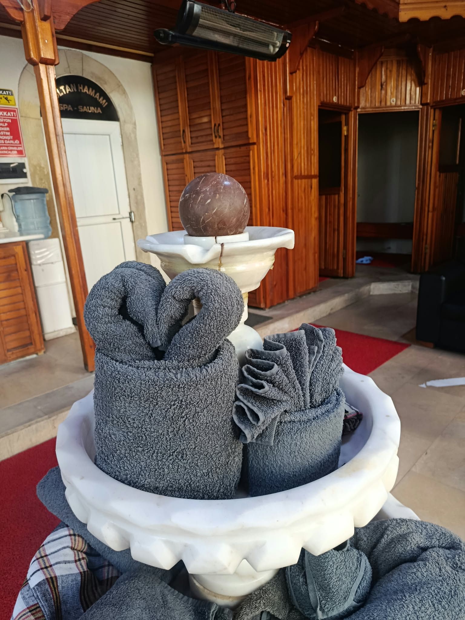 Sultan Hamam Spa girişindeki mermer şadırvan ve özenle katlanmış havlular
